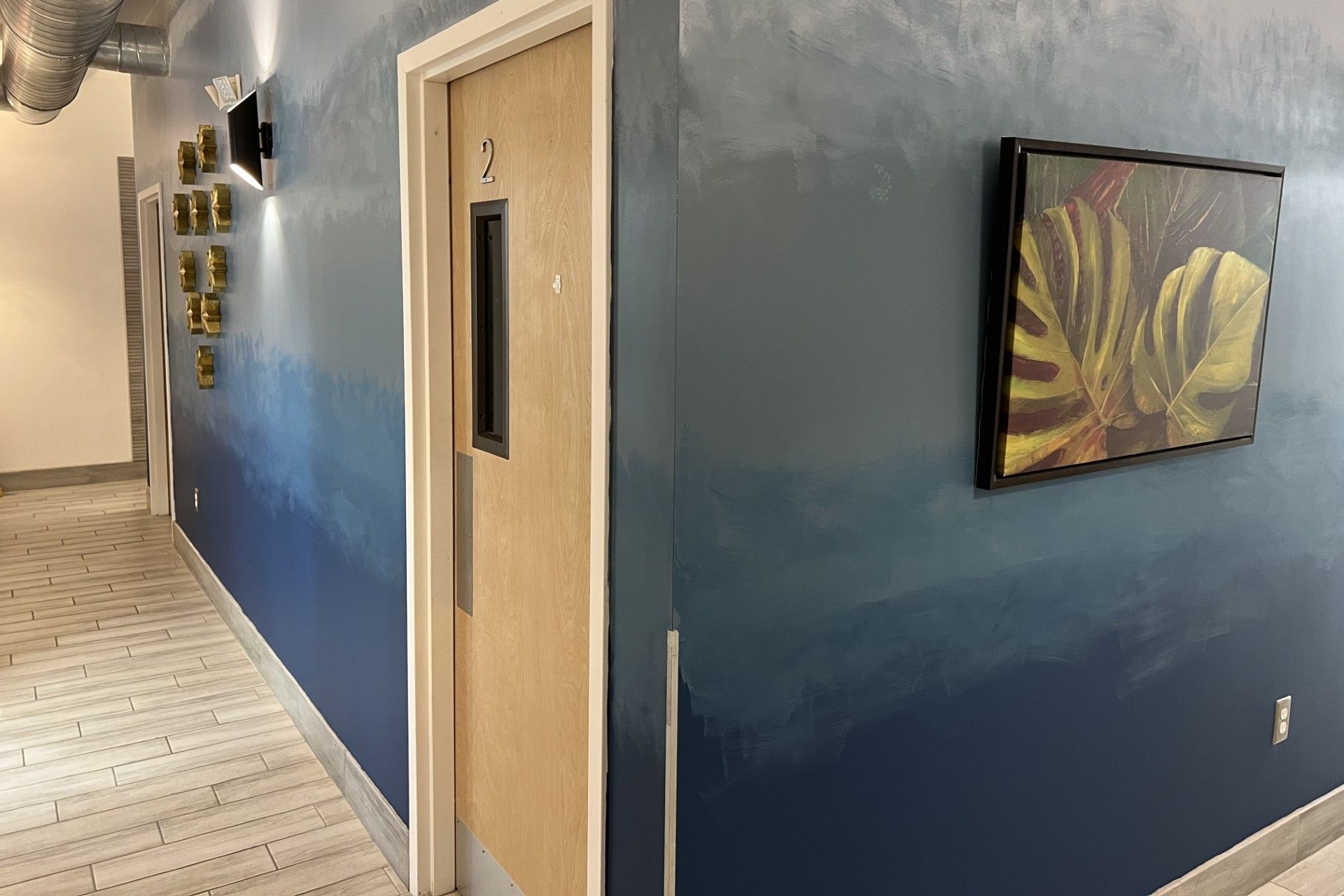 Fort Lauderdale Veterinary Center hallway with exam room door and wall art