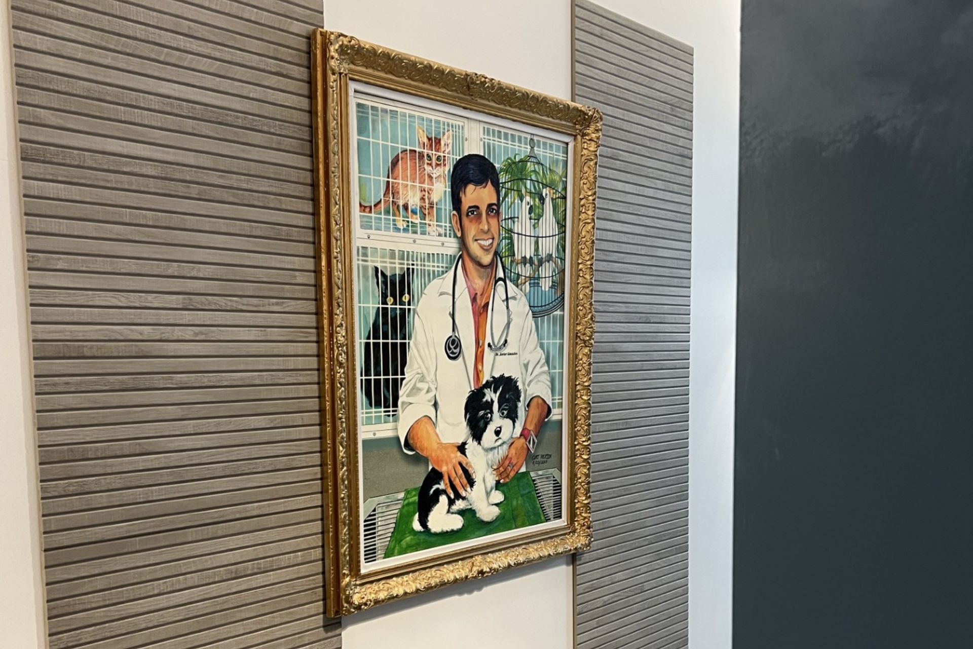 Framed portrait of veterinarian in white coat with stethoscope holding black and white dog